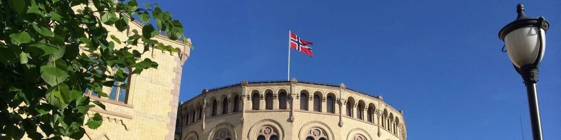 A historic building with a round facade, arched windows, and a flag.