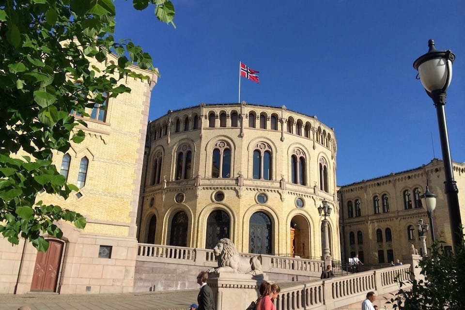 A historic building with a round facade, arched windows, and a flag.