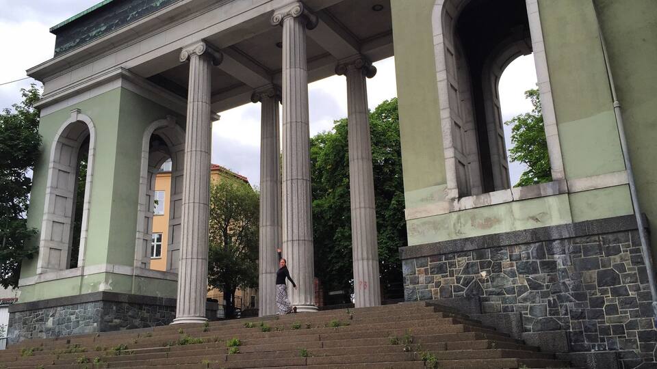 A neoclassical building with large columns and arched doorways.