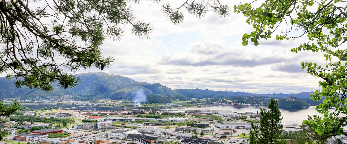 A town with a river, mountains, and a mix of residential and commercial buildings.