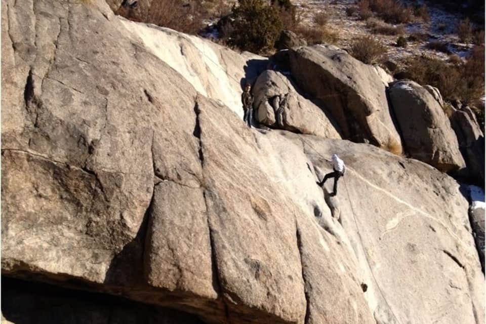 Une grande paroi rocheuse sur laquelle des alpinistes sont en train de grimper.