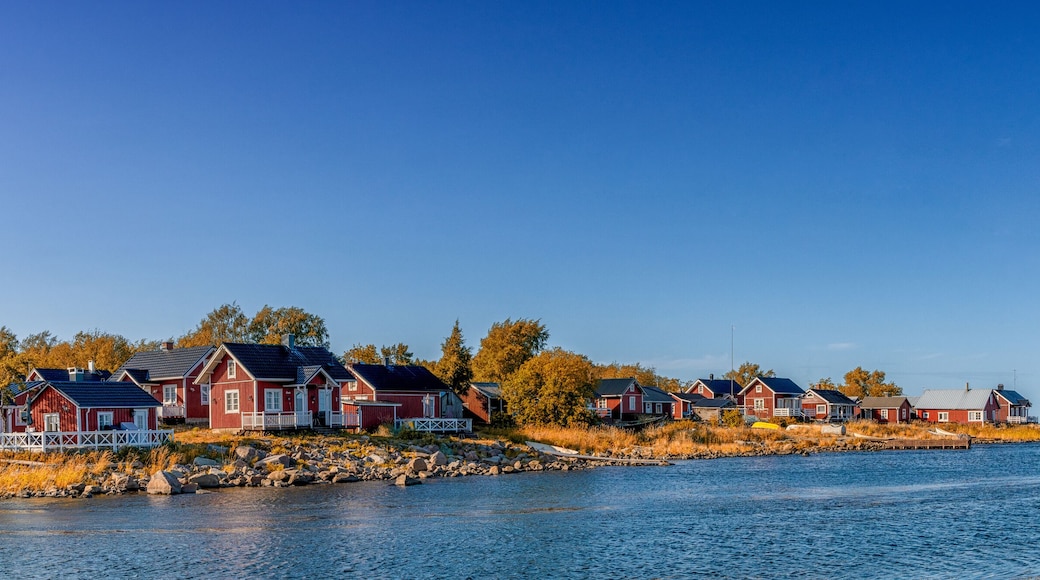idyllic Baltic Sea panorama landscape with red cottages on the shoreline under a blue sky in autumn