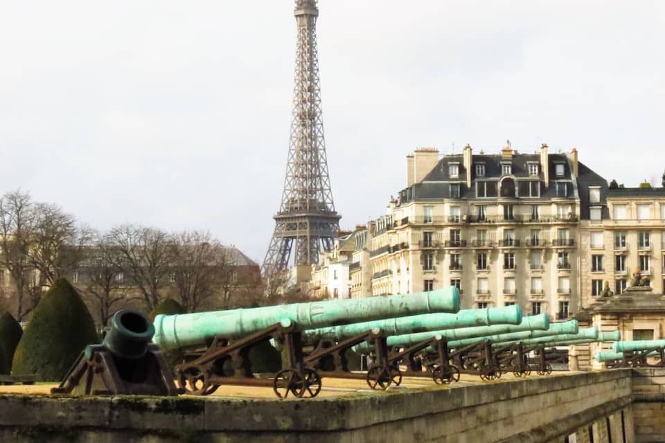 The Eiffel Tower, cannons, and a bridge in Paris.