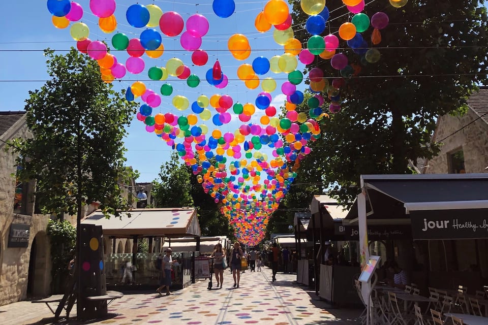 Un carrer decorat amb globus de colors i paviment amb disseny.