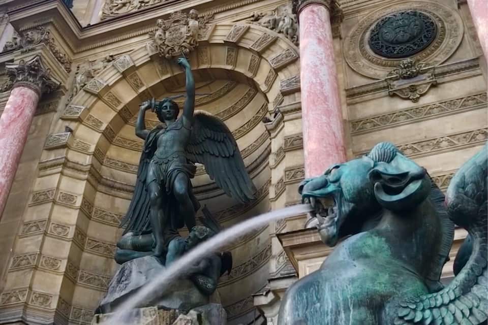 Une fontaine classique ornée de statues d’un ange et d’un lion, le tout mis en valeur par des détails architecturaux élaborés.