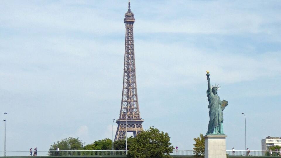 The Eiffel Tower and the Statue of Liberty across the river.