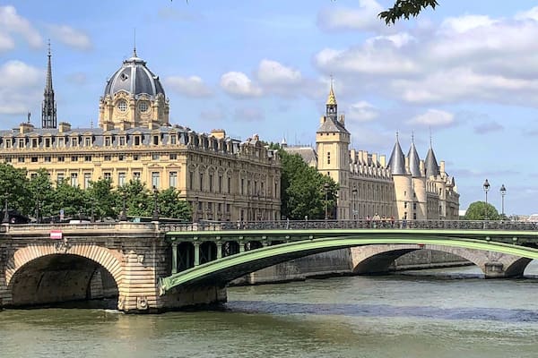 Un pont enjambant une rivière, avec des bâtiments historiques en arrière-plan.