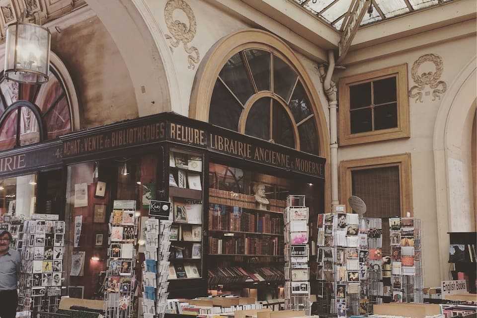 A bookstore with a glass ceiling and ornate architecture.