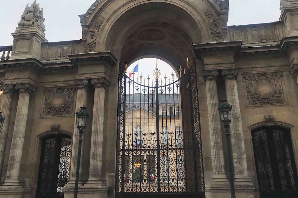 A grand entrance with an ornate archway, a flag, and a decorative gate.
