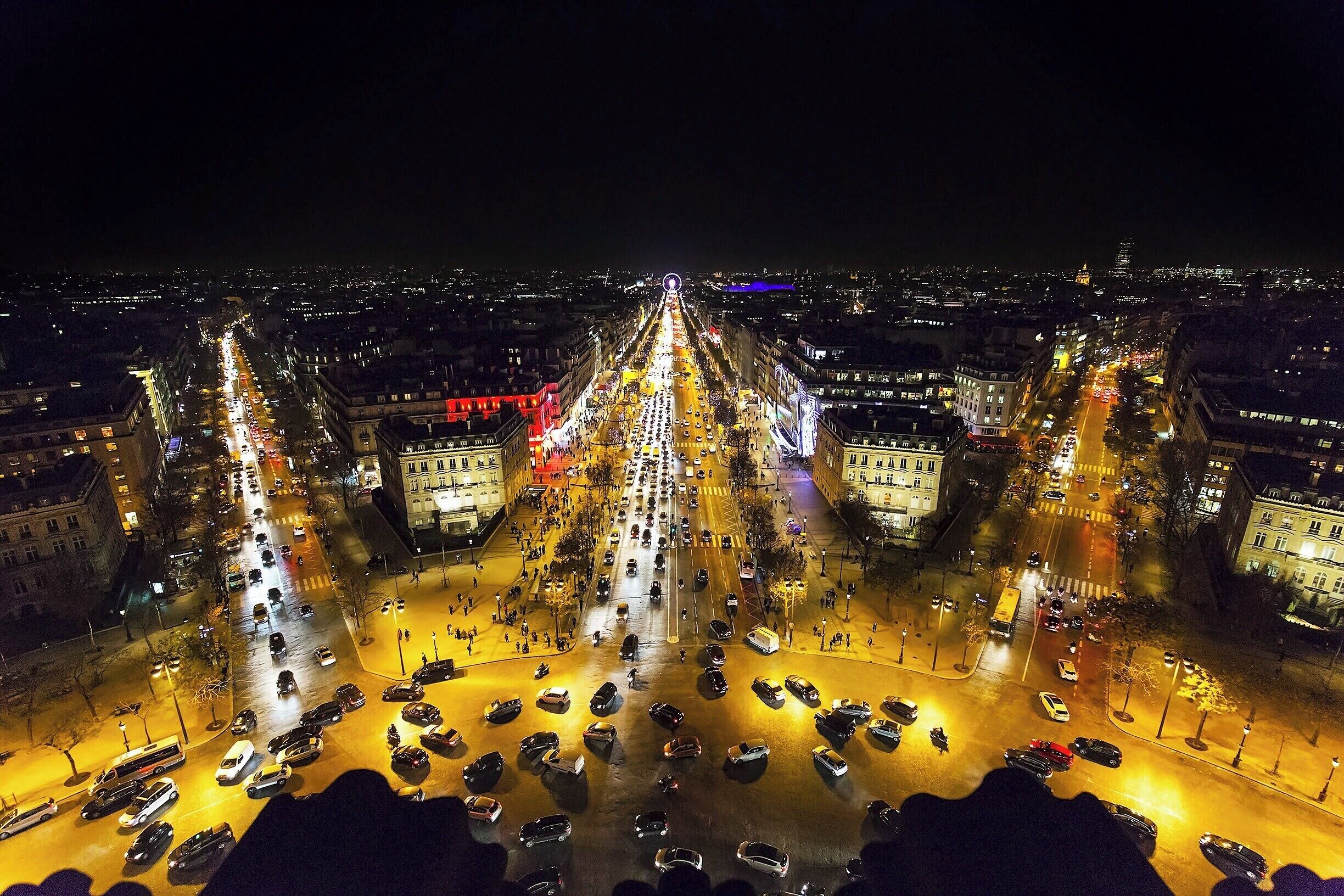 Night view from the top is just fabulous.  The twelve lighted avenues that emanate from Place de l'Étoile make you feel like you're at the center of a giant star.  It's also just a lot of fun to watch the endless traffic mess at the base of the arc.  If you look close you can spot the holiday ferris wheel at Place de la Concorde, as well as the red-wrapped Cartier shop on the Champs-Élysées.