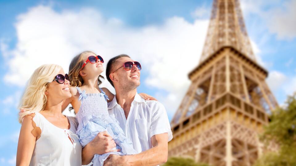 A family with a child in front of the Eiffel Tower.