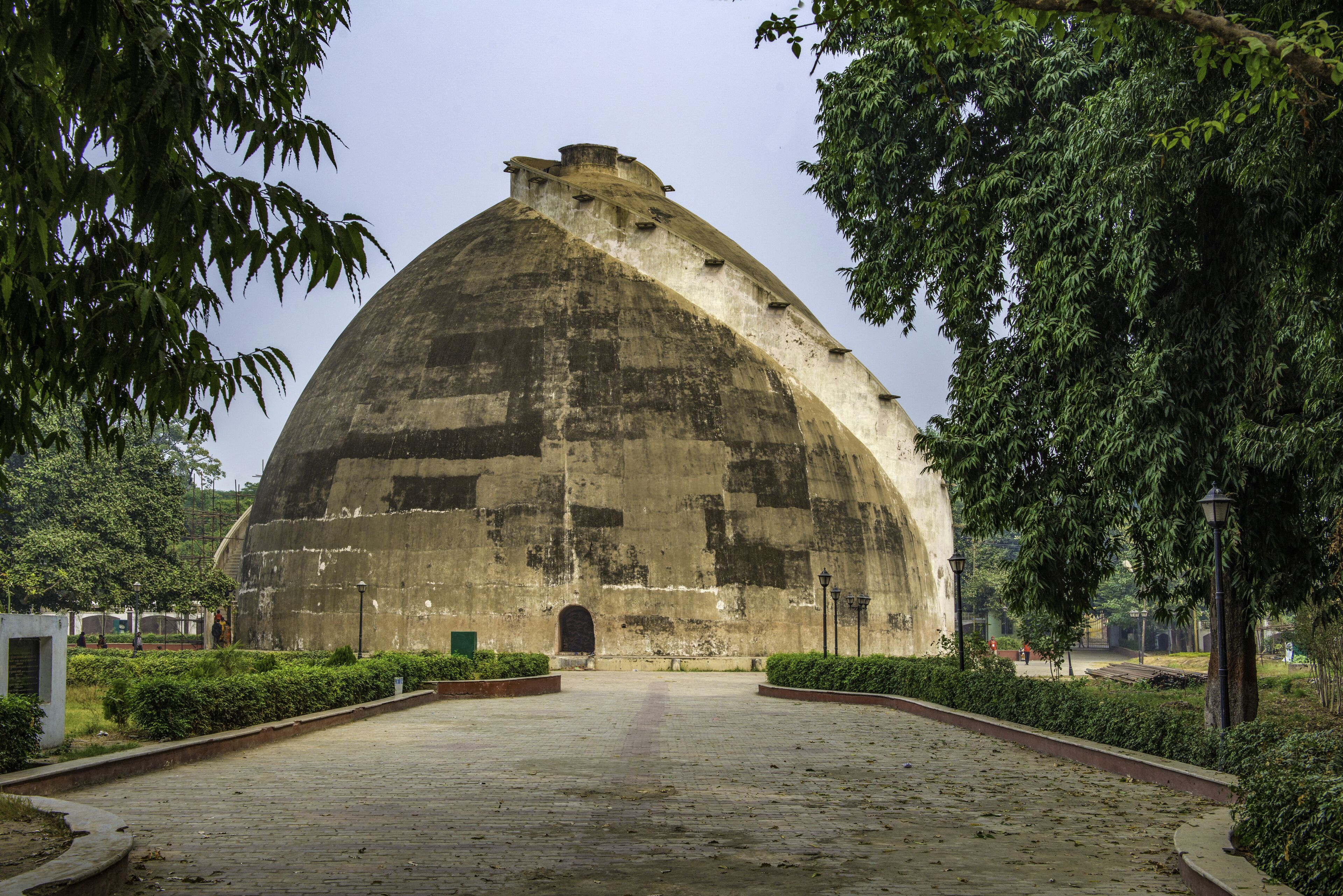 A large, dome-shaped concrete structure surrounded by greenery.