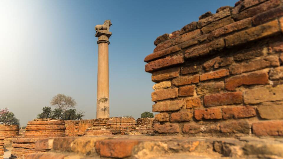 Ancient brick ruins with a tall column featuring a lion statue.