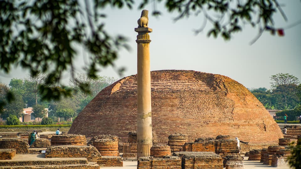 Ancient brick ruins with a large dome and a tall column.