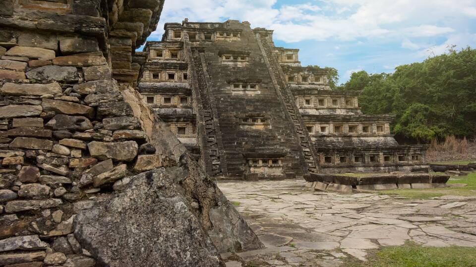 Ancient stone ruins with a large pyramid-like structure and a stone staircase.