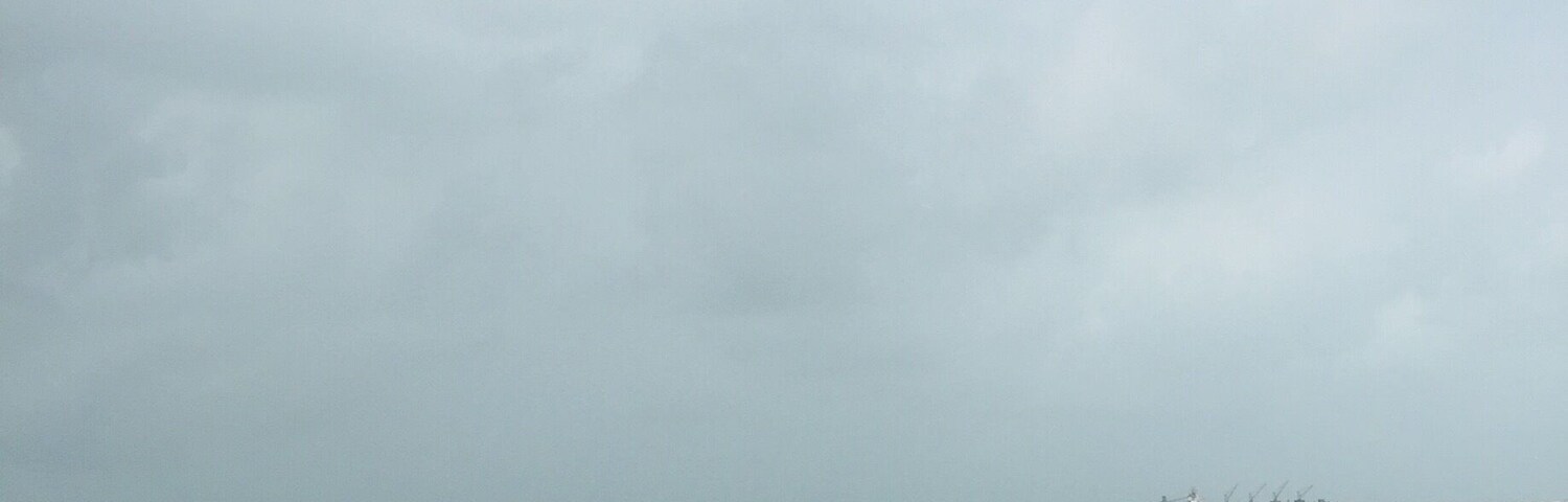 Una playa con olas rompiendo sobre la orilla y un barco distante en el agua.