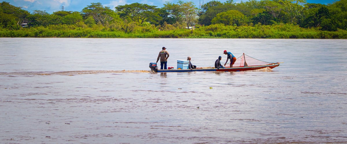 A river with people on a small boat.