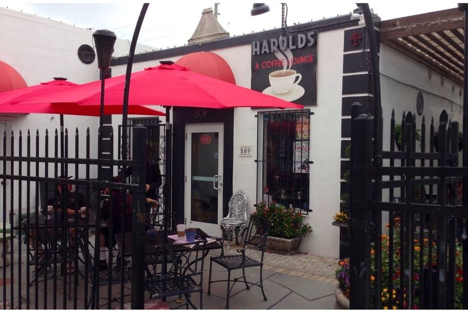 A café named 'Harolds' with outdoor seating and red umbrellas.