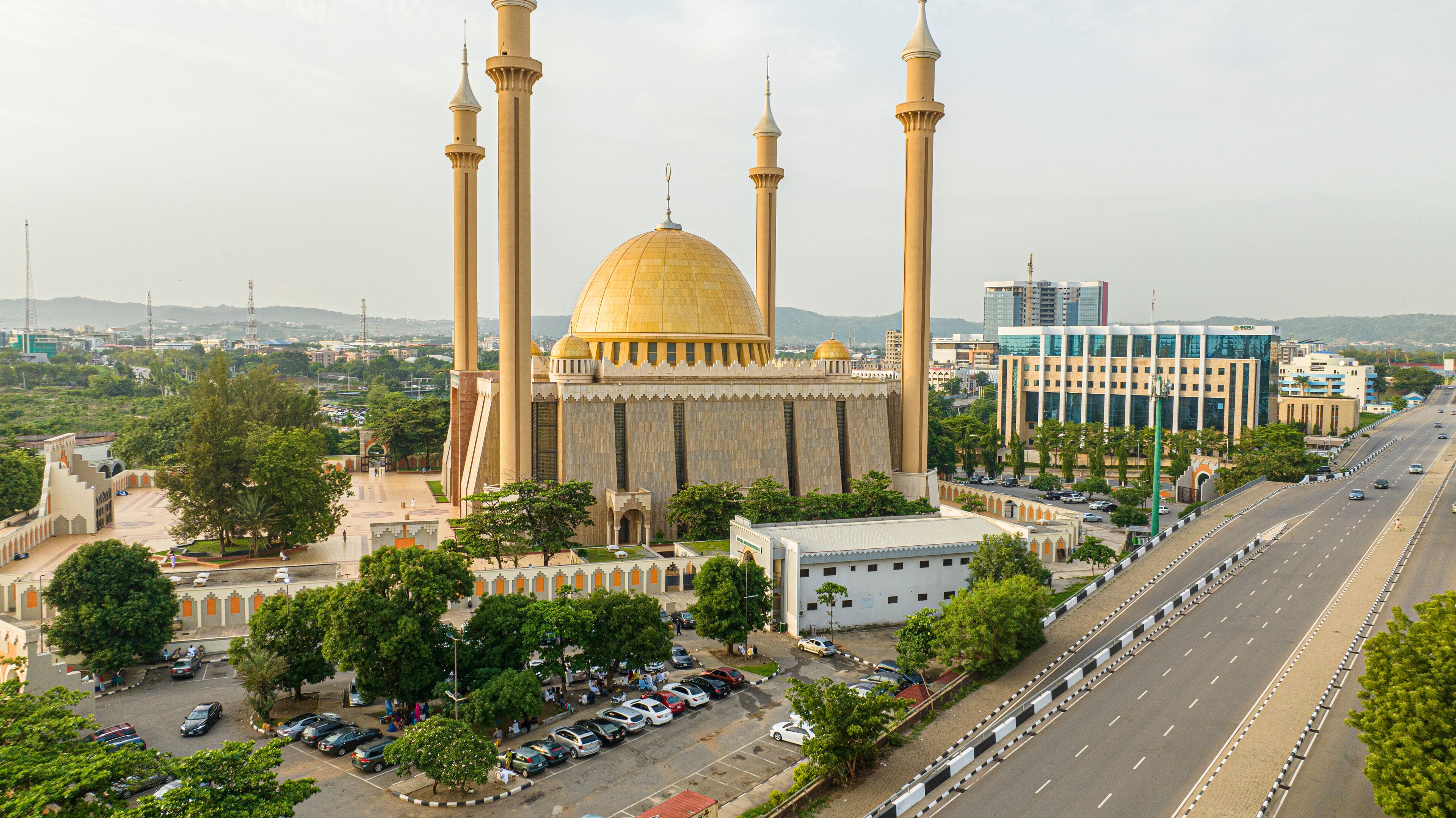Aerial view of beautiful mosque surrounded by urban buildings and greenery in Central Business District, Abuja, Nigeria.
