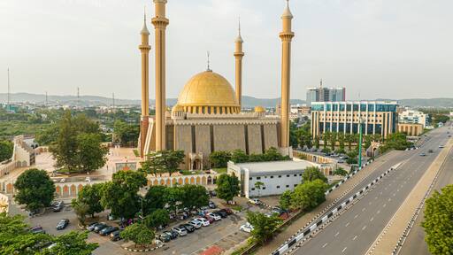Aerial view of beautiful mosque surrounded by urban buildings and greenery in Central Business District, Abuja, Nigeria.