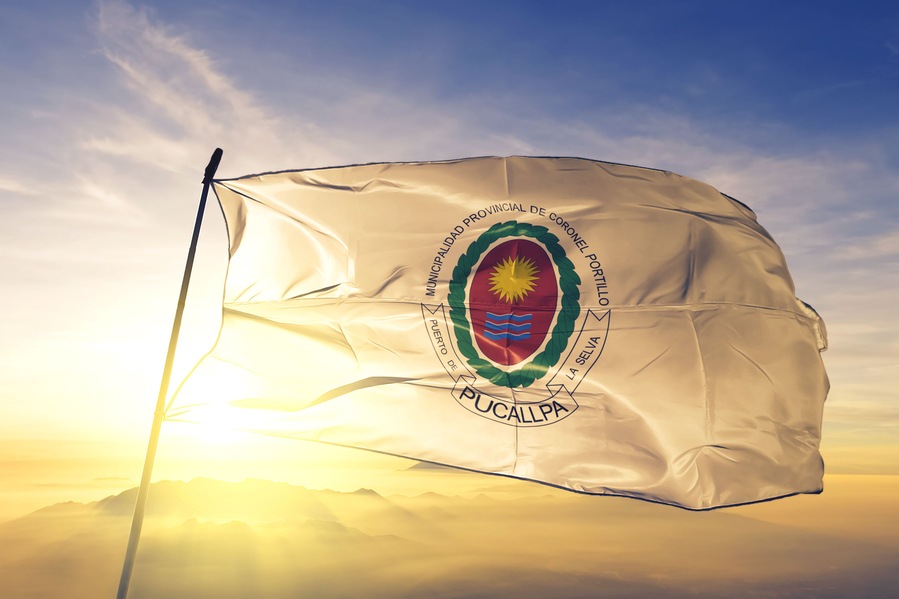 Pucallpa of Peru flag waving on the top sunrise mist fog