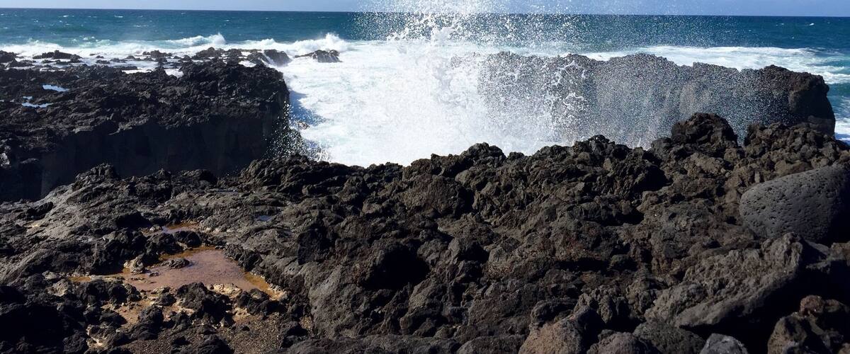 A rocky coastline with waves crashing against the rocks.