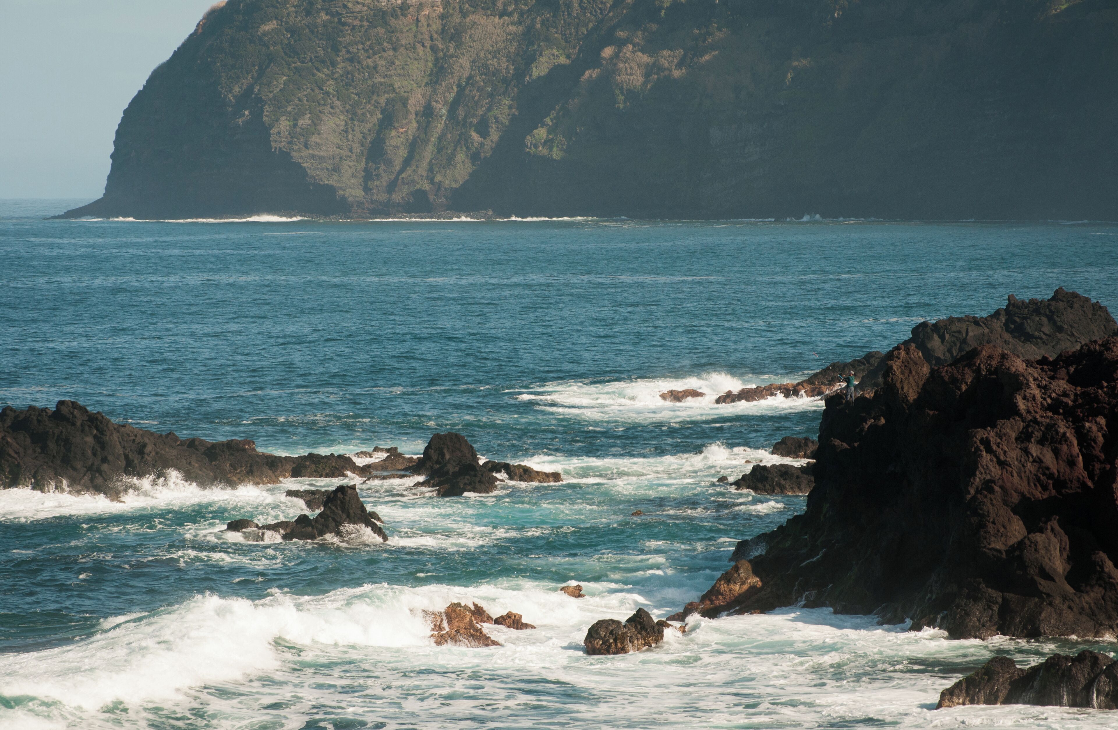 A rocky coastline with waves crashing against the rocks.