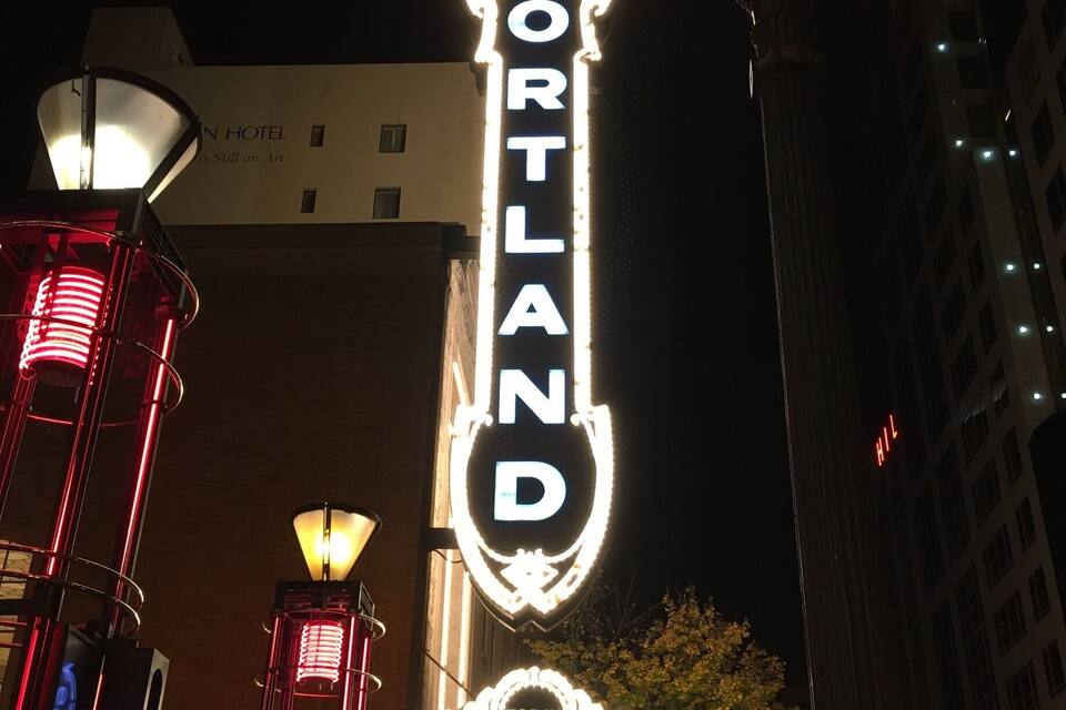 A theater marquee with the name 'PORTLAND' and a sign for the 'OREGON SYMPHONY' featuring 'JOSEPH SWENSEN' and dates 'OCT. 29-31, 2016'.