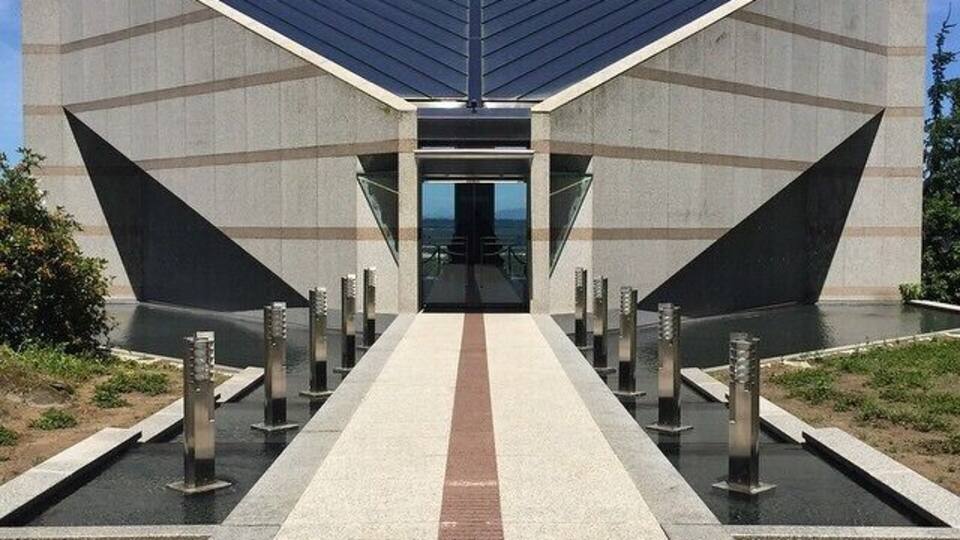 A modern building with a geometric facade and a central entrance.