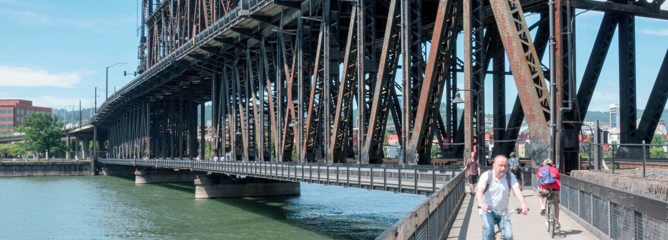 Cross back across the Willamette River along the pedestrian walk below the Steel Bridge to the East side Esplanade.