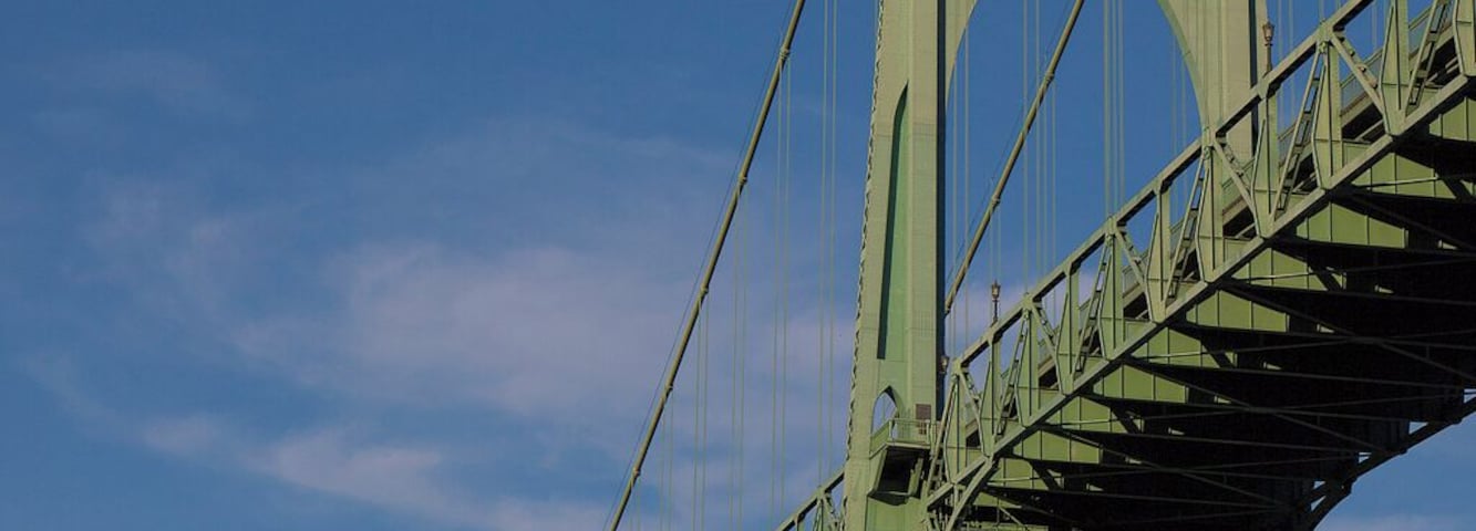 The St. Johns Bridge is a lesson in superlatives. Those gothic cathedral-like towers are 408 feet tall, making it the tallest bridge in the state. The center span is 1,207 feet across, and the total length is 2,069 feet from stem to stern. Making it the longest bridge in the state. It was built in 1931 (as an aside, providing much-needed labor for the area during the depression), which makes it one of the oldest. And perhaps this is all subjective, but it is certainly one of the most beautiful bridges you are likely to see anywhere or any time.
Oh, we have to add this, it is probably the only bridge ever to stand as a symbol for a widely-popular network television show. The name escapes me now, but I can certainly tell you that the residents of Portland do not necessarily take a grim view of that.
https://en.wikipedia.org/wiki/St._Johns_Bridge