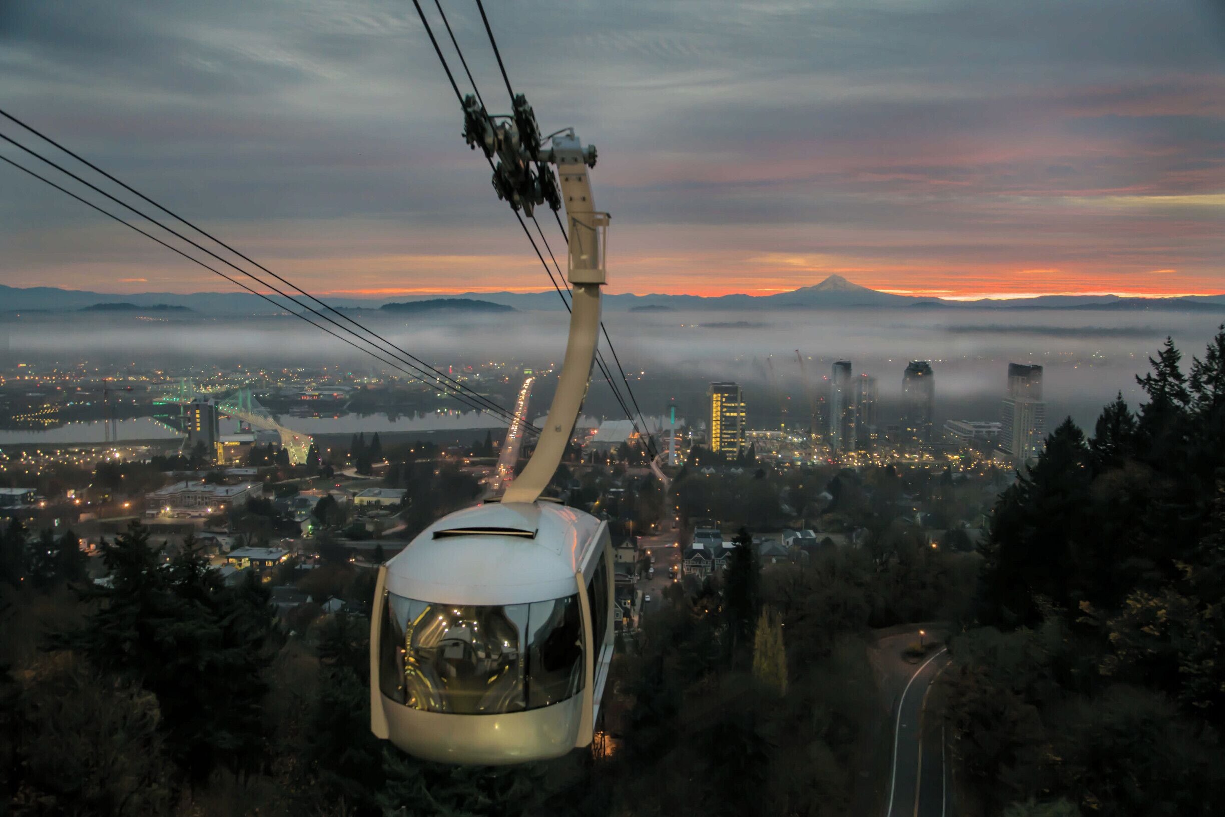 Sunrise from the upper tram terminal at Oregon Health Science University. Timing is everything in photography. I have waited a year to get the right timing and weather for this shot. For those fortunate enough to ride the tram daily this is a common sight. Mount Hood in the background.