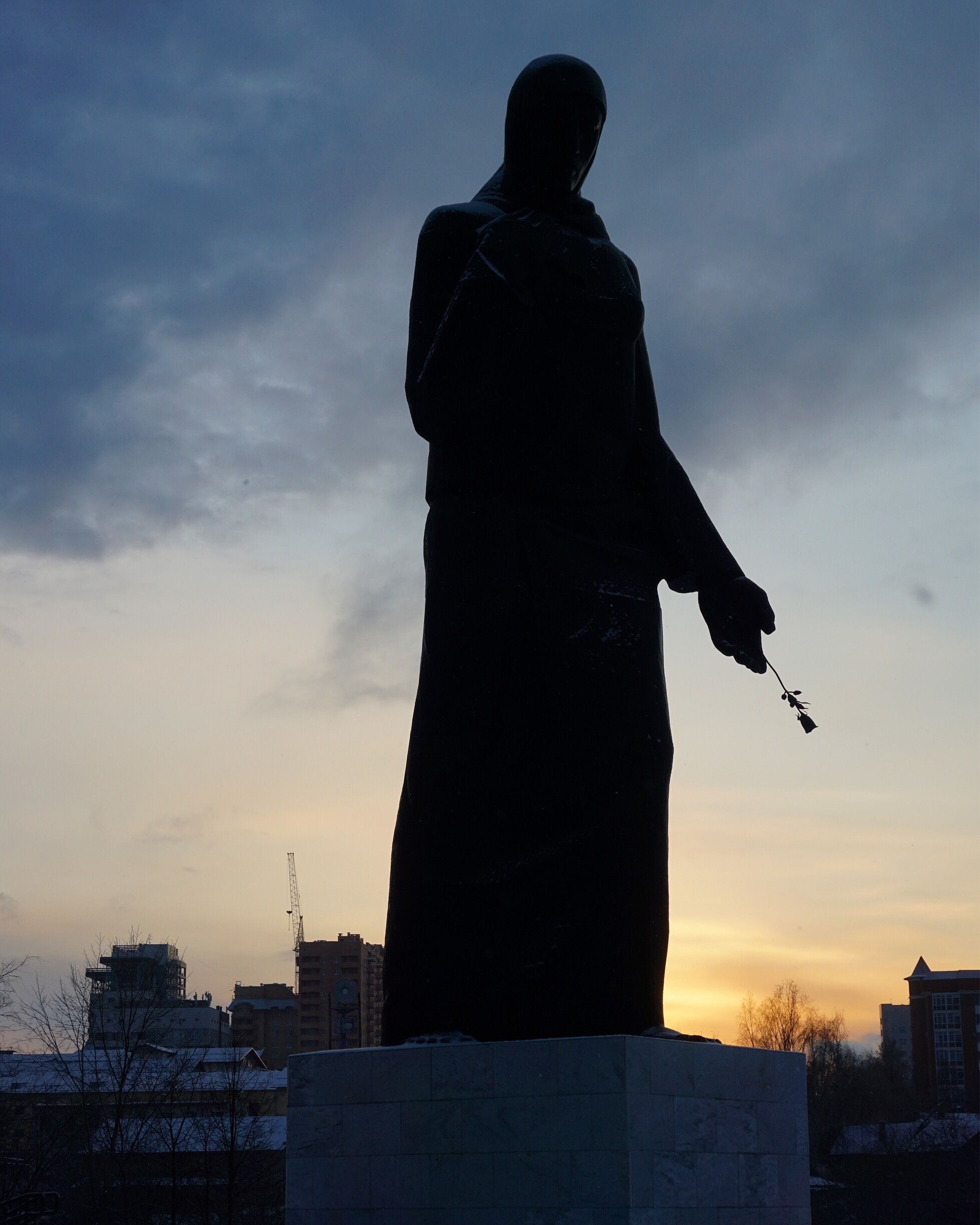 She stands at the edge of the cemetery, as if she knows she has to enter, but doesn't want to do so. 