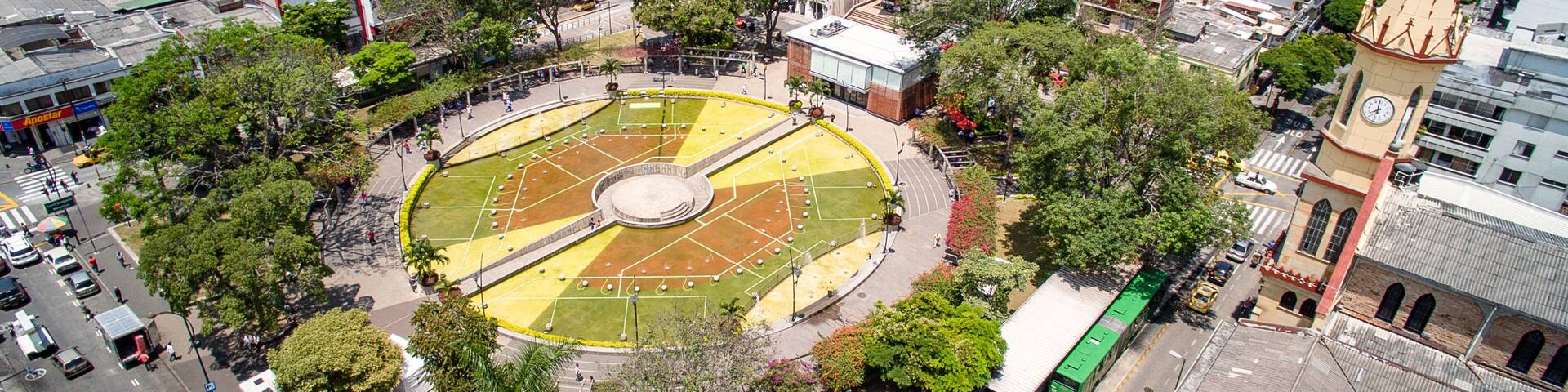 A cityscape with a central circular park, surrounding buildings, and a prominent clock tower.