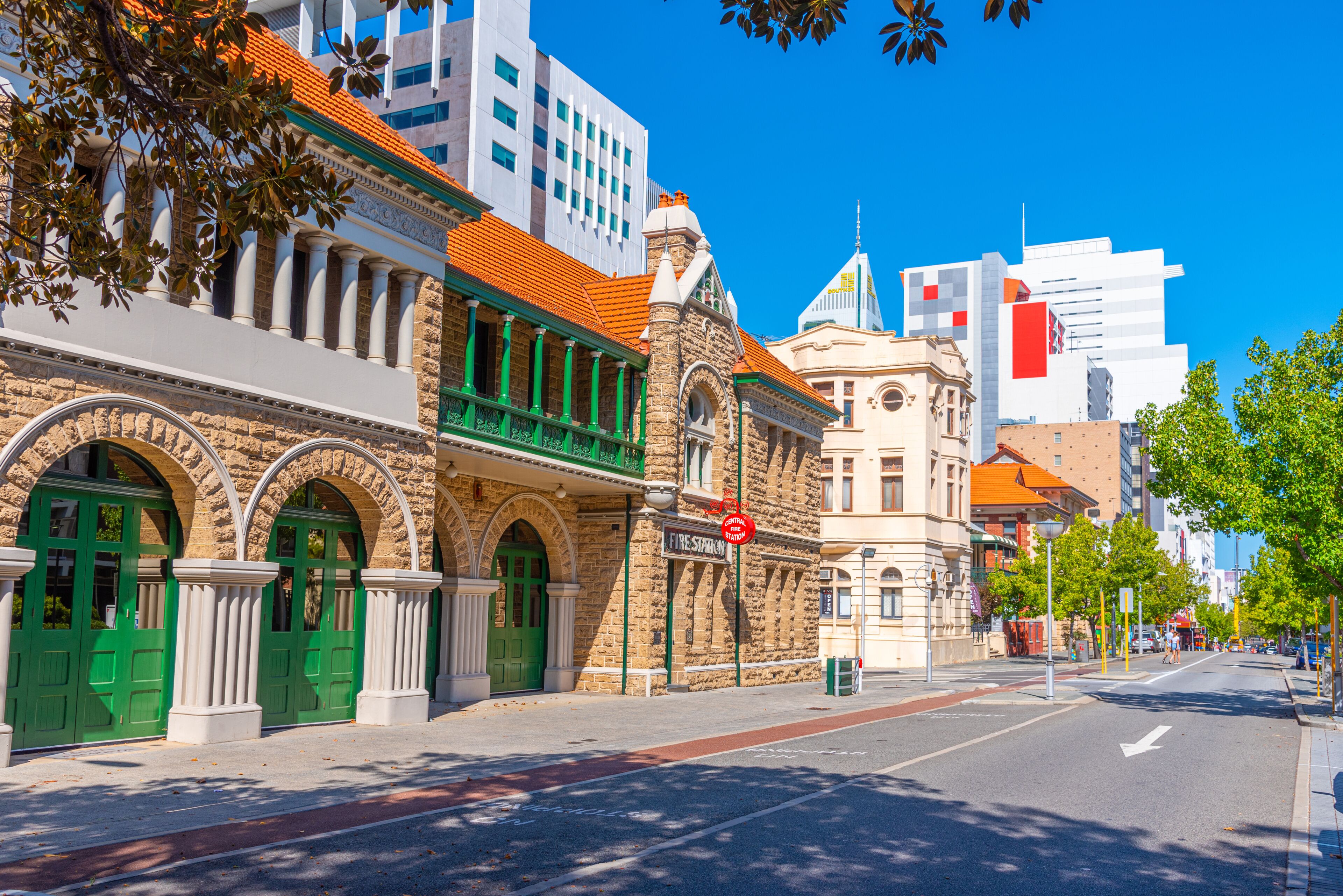 Una calle histórica con arquitectura colonial, una señal de calle y edificios modernos al fondo.