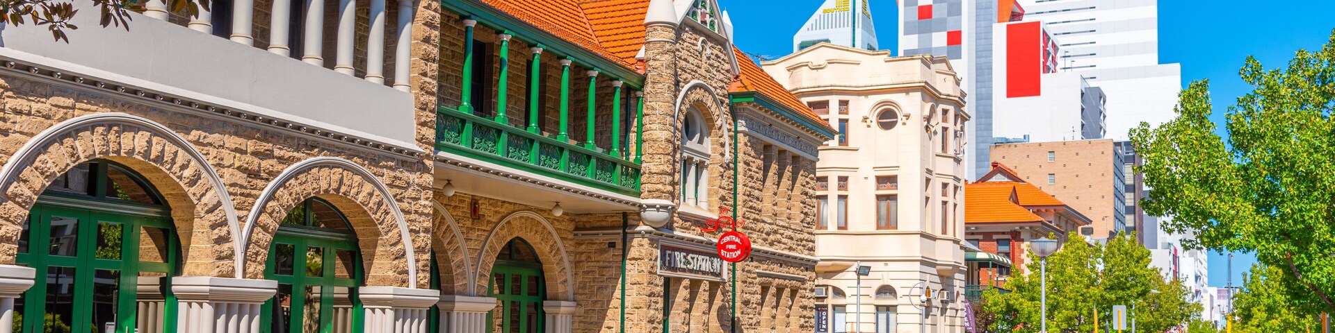 Una calle histórica con arquitectura colonial, una señal de calle y edificios modernos al fondo.