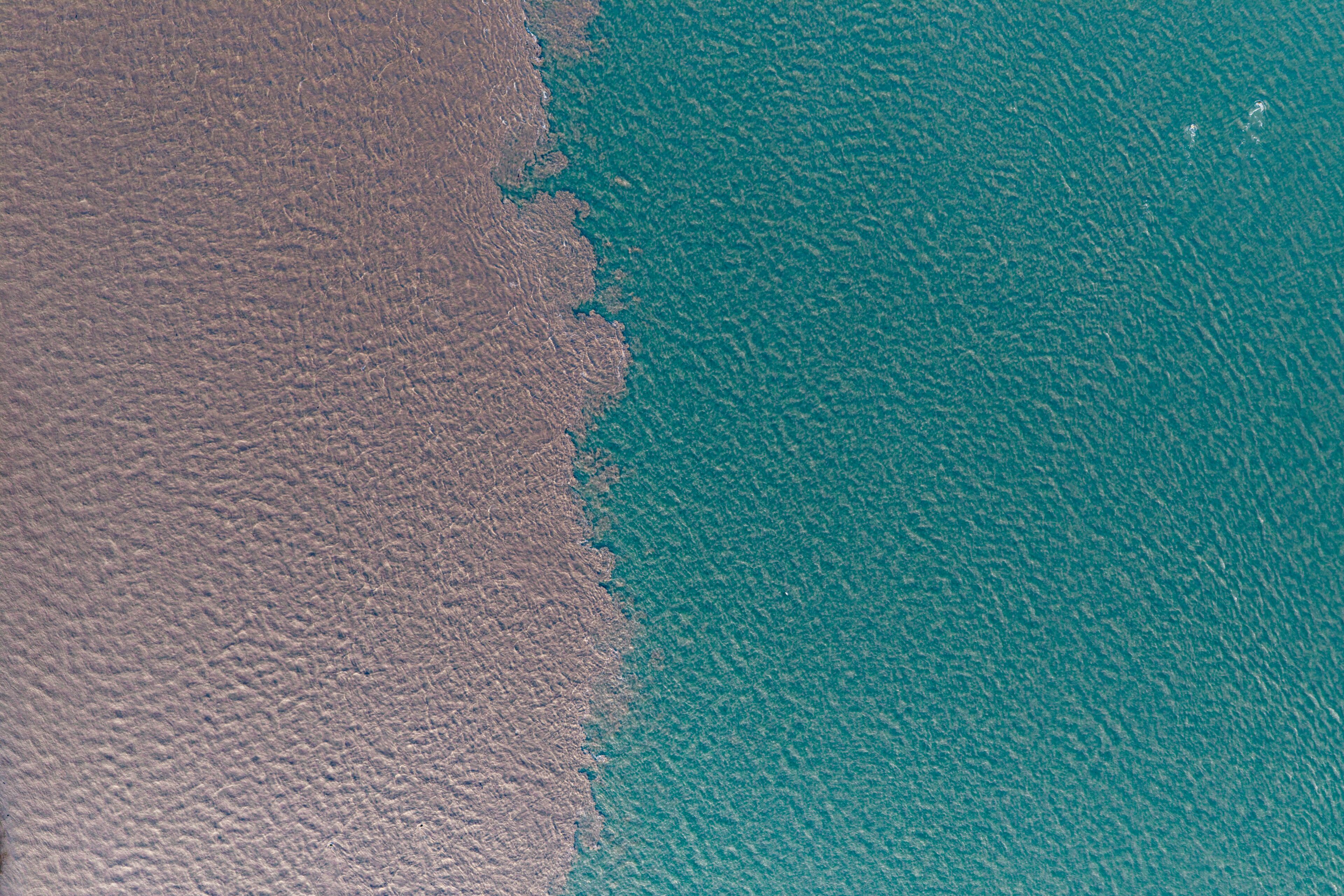 A coastal landscape with a sandy beach and turquoise waters.