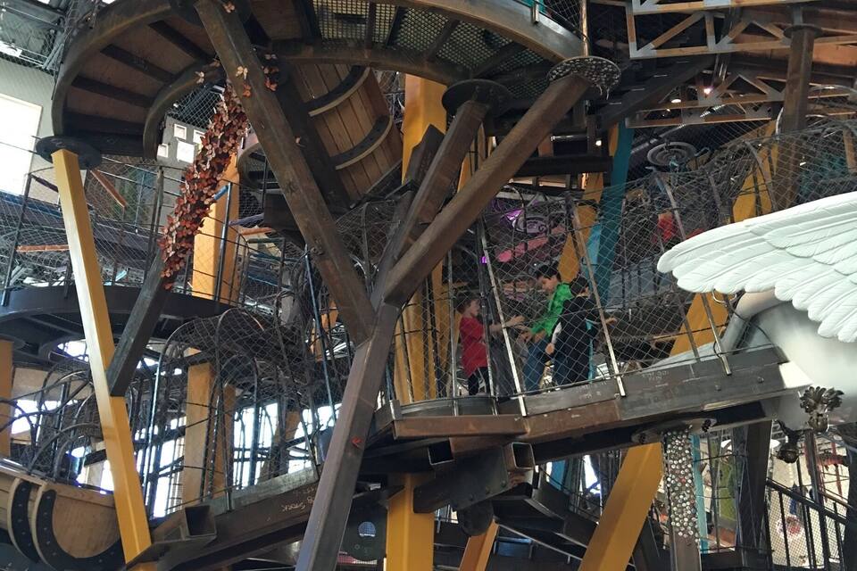 Una estructura de joc de diversos nivells, amb zones d'escalada en xarxa i un gran tambor giratori.