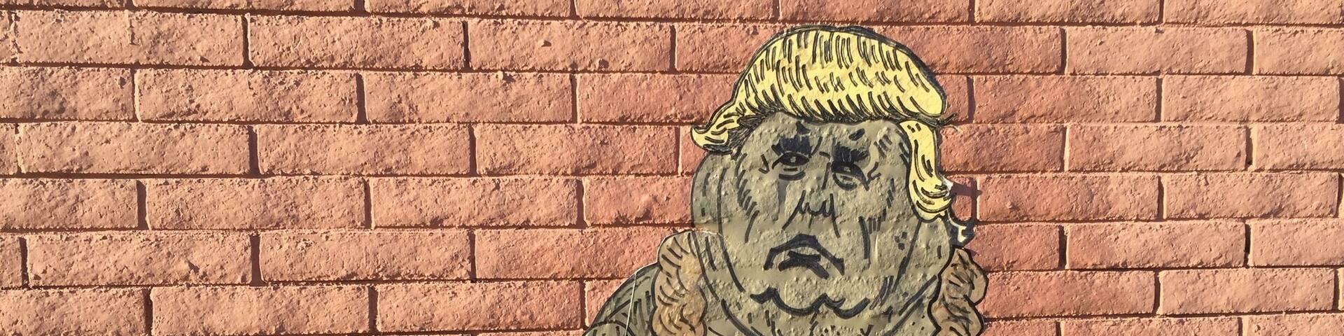 A mural of a figure with a fur coat and a hat on a brick wall.
