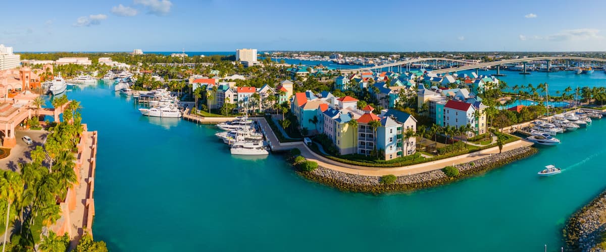 Un port de plaisance avec des bateaux, un pont et des bâtiments aux couleurs vives.
