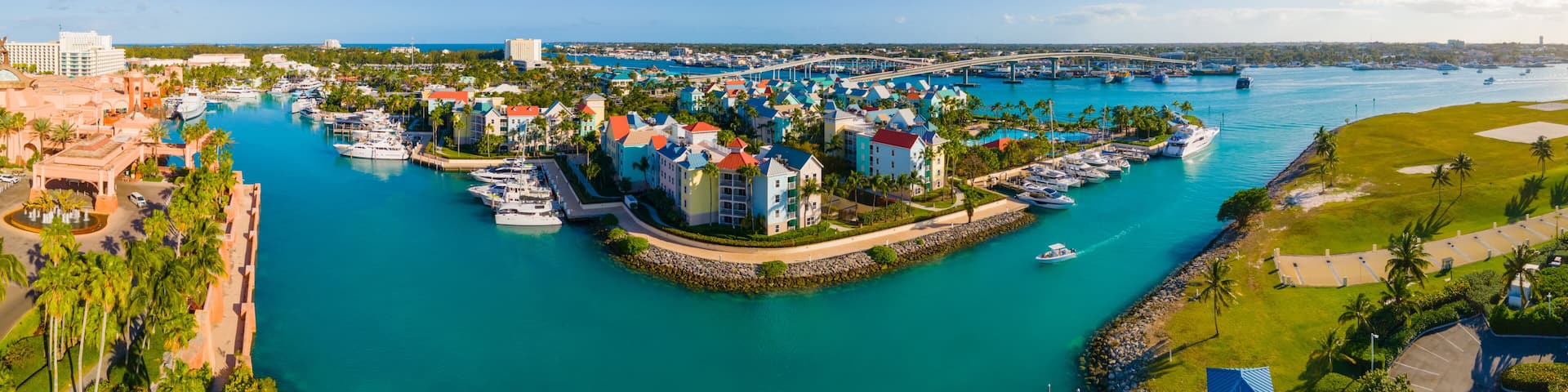 A marina with boats, a bridge, and colorful buildings.