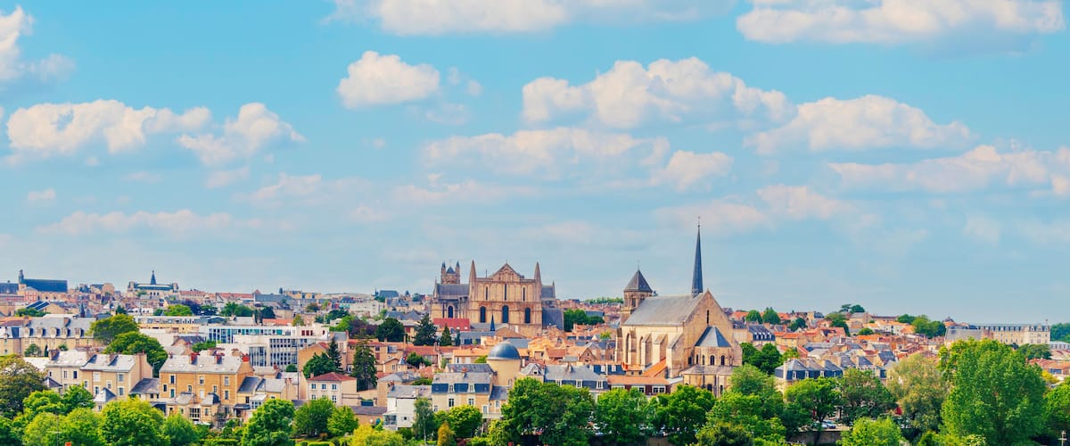 A cityscape with a prominent cathedral and spires, surrounded by residential buildings and greenery.