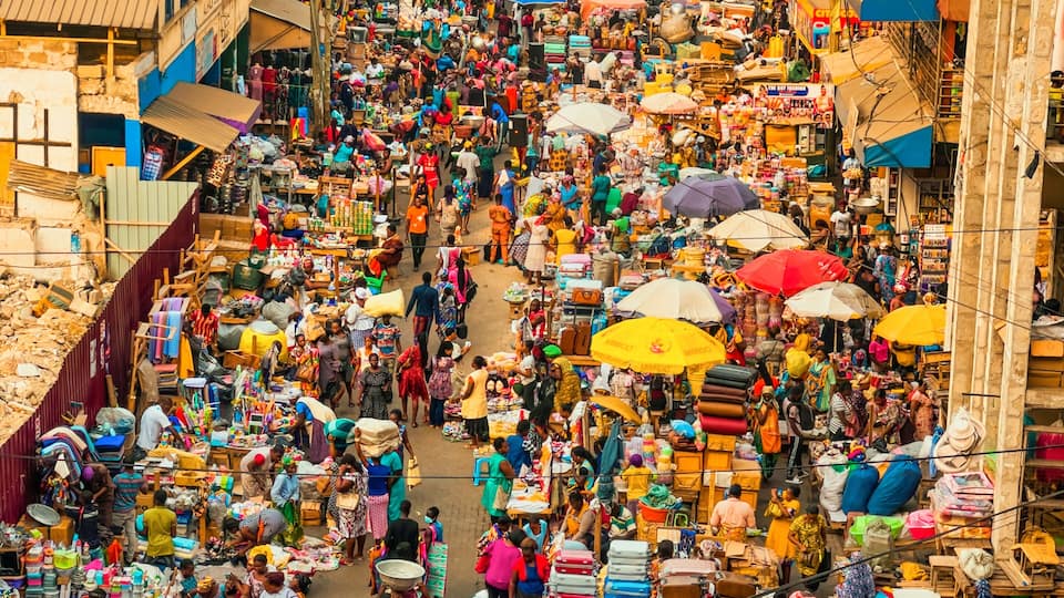 A bustling market street with numerous stalls and people.