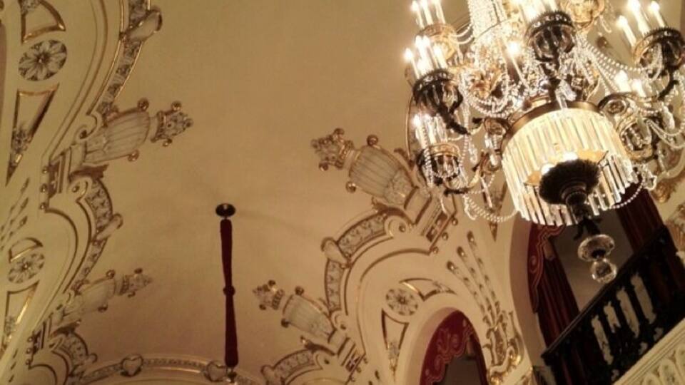 An ornate chandelier with multiple lights and intricate designs.
