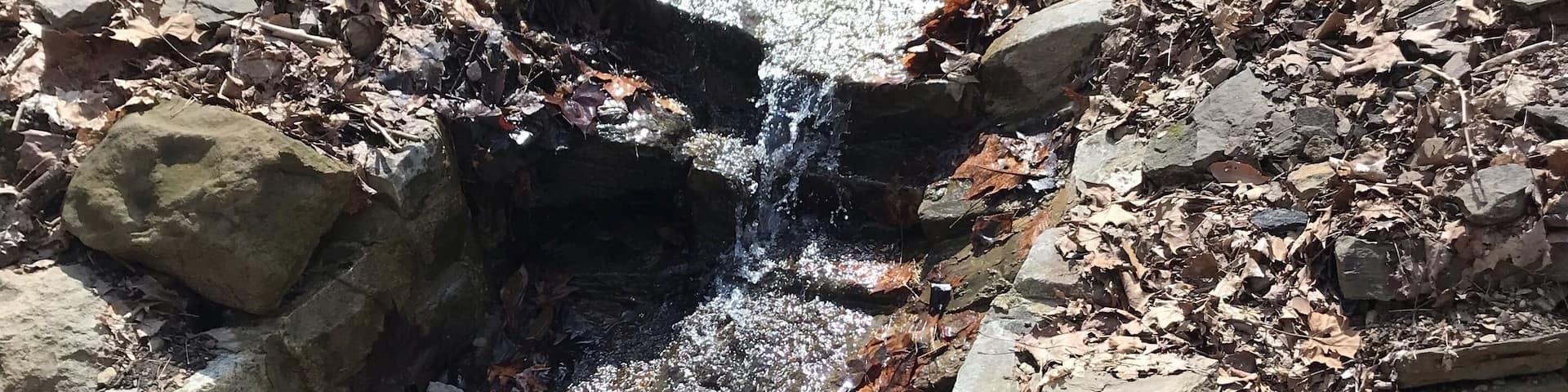 A near frozen stream runs down a rock path #adventure