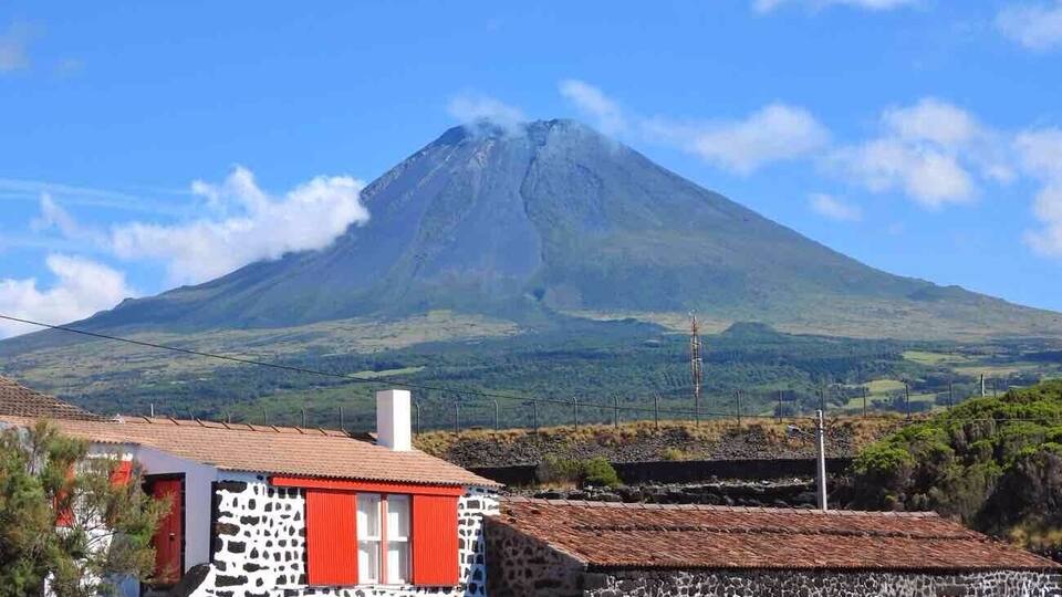 A village with stone houses and a mountain in the background.