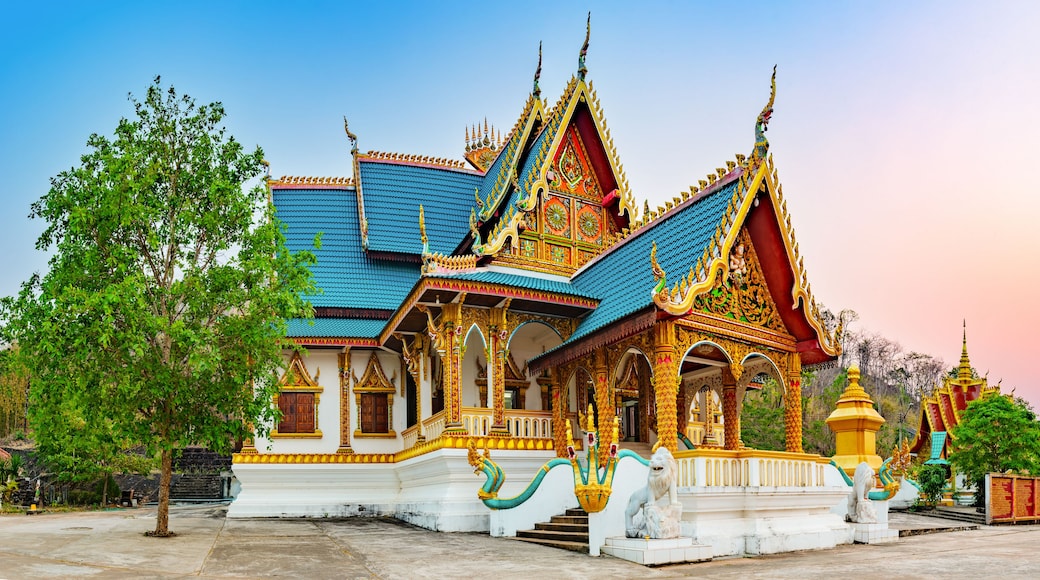 A traditional Thai temple with ornate architecture, a blue roof, and golden decorations.