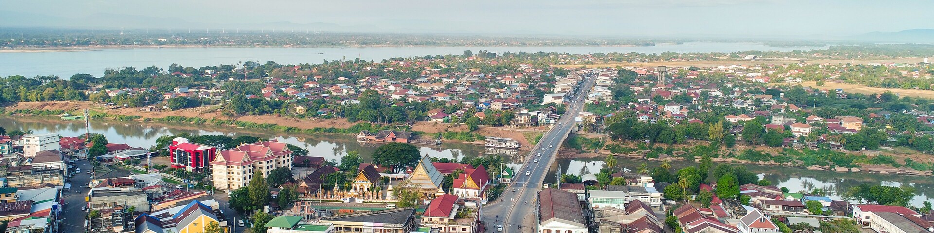 A river running through a town with colorful buildings and a large bridge.
