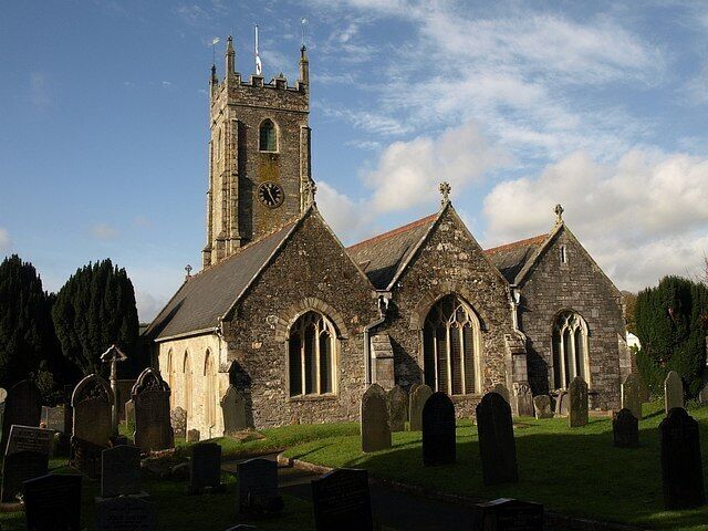 St Mary's church, Tamerton Foliot. Very similar to 84135, and the most striking view of the church, with its three gables, "the roofs made uniform in the C19" (Cherry & Pevsner), and the tower rising above. This is taken from near the gate at the east end of the churchyard.