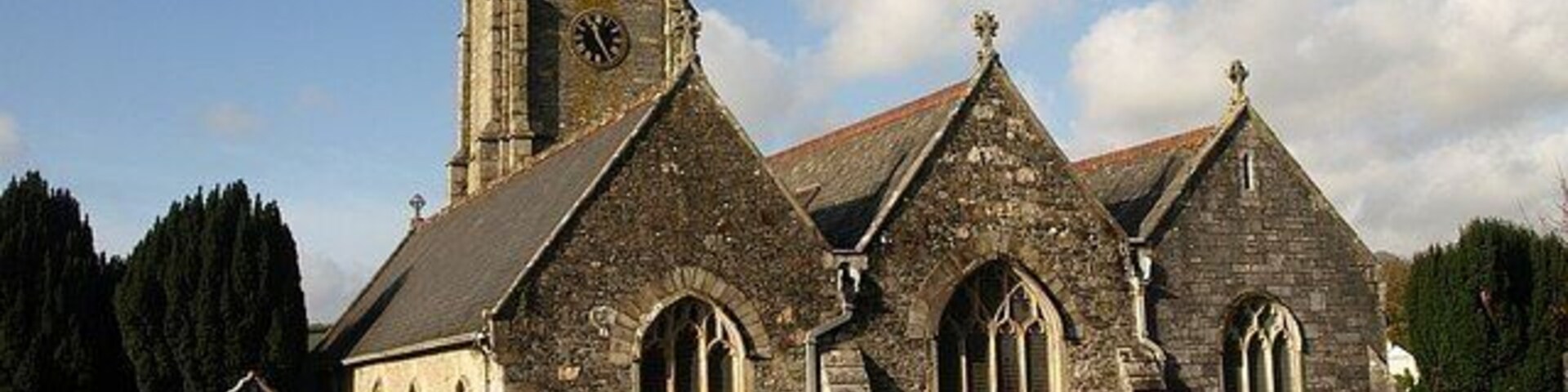 St Mary's church, Tamerton Foliot. Very similar to 84135, and the most striking view of the church, with its three gables, "the roofs made uniform in the C19" (Cherry & Pevsner), and the tower rising above. This is taken from near the gate at the east end of the churchyard.